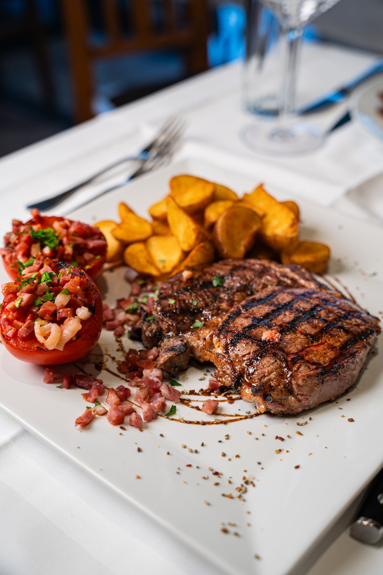 Grilled steak with potatoes and a stuffed tomato