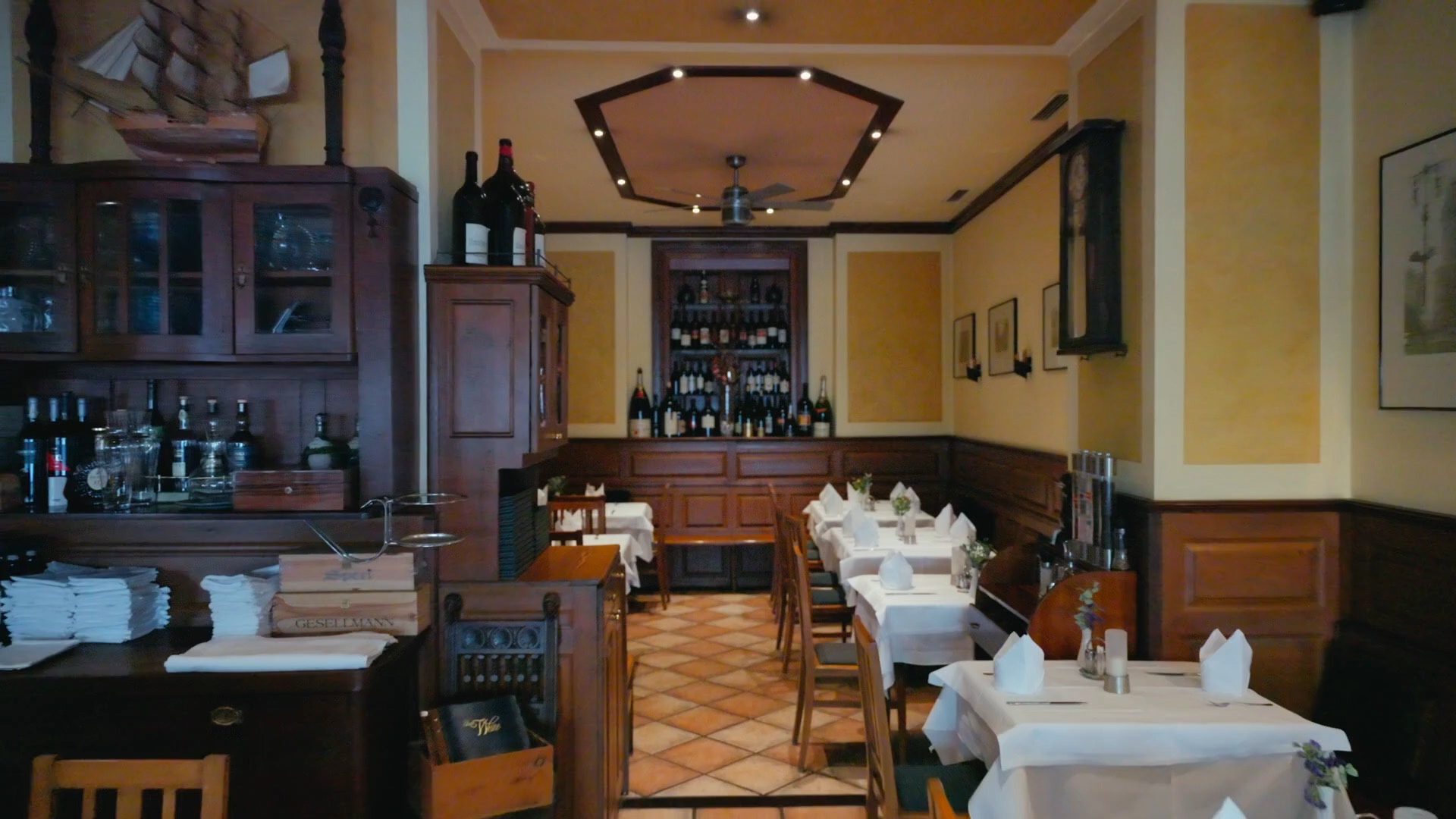 Dining room of PORTERHOUSE, with set tables and the wine wall